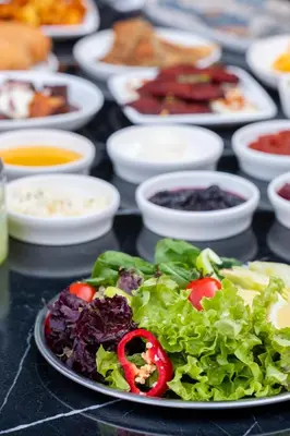 a plate of salad on a table with other plates of food at Backyard Sapanca in Sapanca