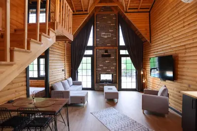 a living room with wooden walls and a staircase at MSC Bungalov Sapanca in Sapanca