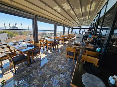 a restaurant with wooden tables and chairs and windows at Anthemis Hotel in Istanbul