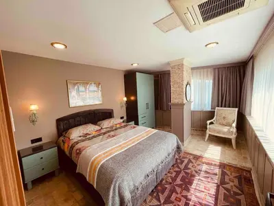 a bedroom with a large bed and a chair at Country , two bedroom and livingroom on Main Street in Çekmeköy