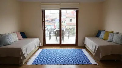 a room with two beds and a table with a patio at Stylish Triplex with Turkish Bath, Terrace, Central Location in Istanbul