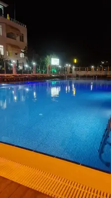 a large blue swimming pool at night at Aydın Motel in Marmara