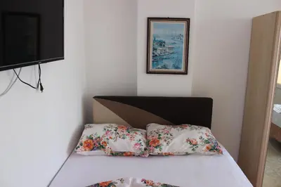 a bedroom with a bed with two pillows and a television at Aydın Motel in Marmara