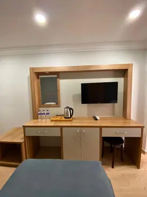 a bedroom with a desk with a tv on a wall at Kafkas Hotel Istanbul in Istanbul