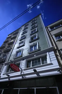 a tall white building with a sign on it at Kafkas Hotel Istanbul in Istanbul