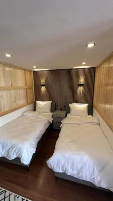 two beds in a room with wooden walls at Golden Wood Suites in Istanbul