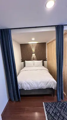 a bedroom with a bed with blue curtains at Golden Wood Suites in Istanbul