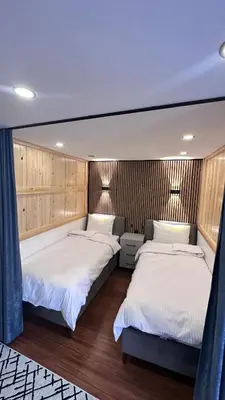 two beds in a bedroom with wood paneling at Golden Wood Suites in Istanbul