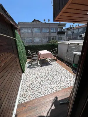 a patio with a table and chairs on a rug at Mutlu terrace in Istanbul