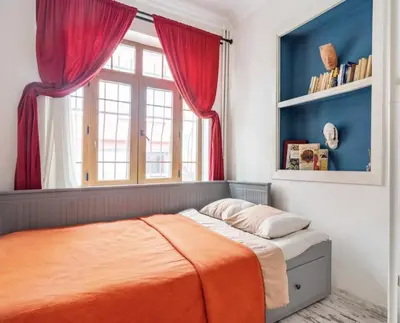 a bedroom with a bed with red curtains and a window at House of Soul & Triplex with a Winter Garden in Istanbul