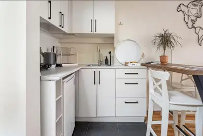a kitchen with white cabinets and a wooden table at House of Soul & Triplex with a Winter Garden in Istanbul