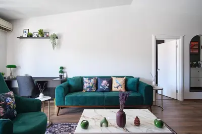 a living room with a green couch and a table at Cozy Penthouse with the Balcony in Istanbul