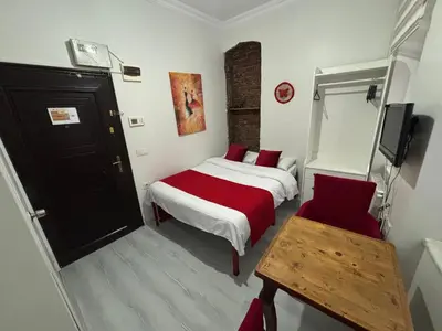 a bedroom with a bed and a table and a tv at Istanberry - Scarlet Apartments in Istanbul