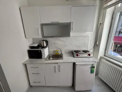 a small kitchen with a sink and a microwave at Istanberry - Scarlet Apartments in Istanbul