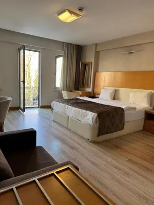 a hotel room with a large bed and a couch at PALMIYE hotel SUITES in Istanbul