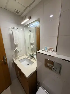 a bathroom with a sink and a mirror and a toilet at PALMIYE hotel SUITES in Istanbul