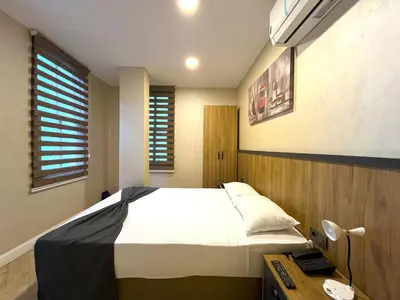 a bedroom with a bed and a desk and window at Valens Butik in Istanbul