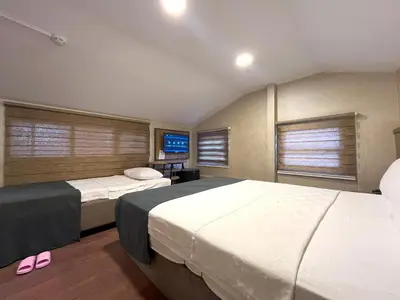 a bedroom with two beds and a flat screen tv at Valens Butik in Istanbul