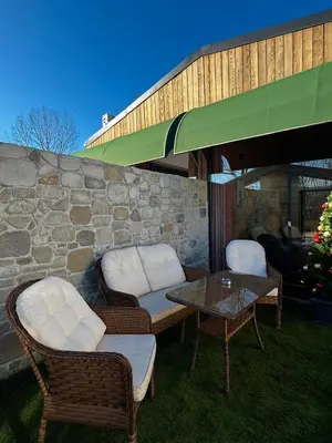 a patio with chairs and a table and a stone wall at Prime Suites in Kadıköy