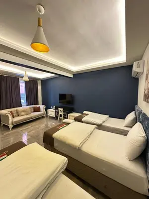 a room with two beds and a blue wall at Sevil new apart in Istanbul