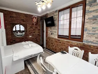 a room with two beds and a table and chairs at Sultanahmet Apart Hotel in Istanbul