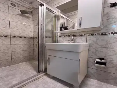 a white bathroom with a sink and a shower at Sultanahmet Apart Hotel in Istanbul