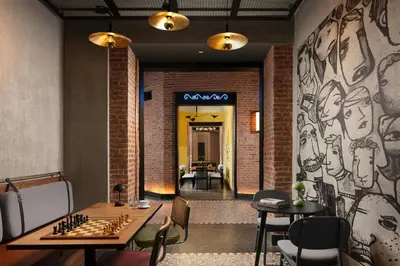 a room with two tables and a chessboard on a wall at Moxy Istanbul Taksim in Istanbul