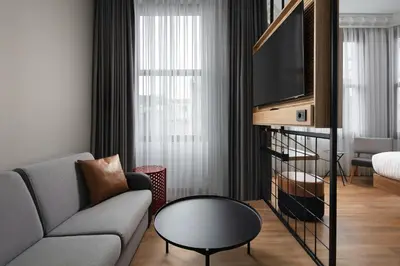 a living room with a couch and a tv at Moxy Istanbul Taksim in Istanbul