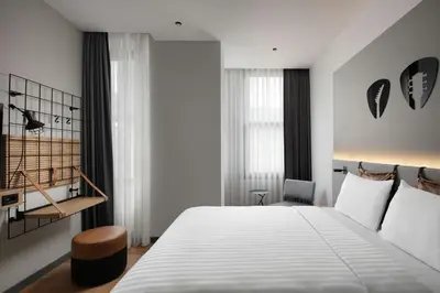 a bedroom with a large bed and a chair at Moxy Istanbul Taksim in Istanbul