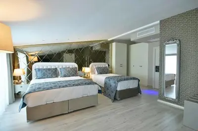 a large bedroom with two beds and a mirror at Perada Suite & Room in Istanbul
