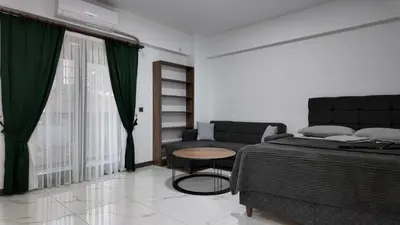 a bedroom with a bed and a table and a couch at farazarooms in Serdivan