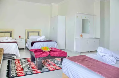 a bedroom with two beds and a table with a bowl of fruit on it at Hotel yeniçiftlik in Yeniçiftlik