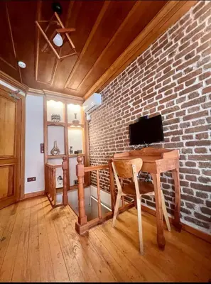 a room with a wooden table and a brick wall at Authentic Turkish Home Standard Room in Istanbul
