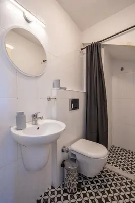a bathroom with a sink and a toilet and a mirror at Raya Cihangir Suites in Istanbul