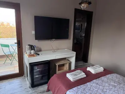 a bedroom with a tv on the wall and a bed at Keyfe Kadir Garden Butik Otel in Orhangazi