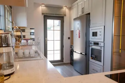 a large kitchen with a refrigerator and a stove at Comfort 4 bedroom villa yalova see view in Termal