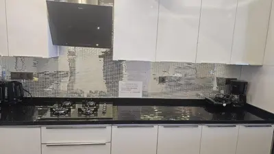 a kitchen with white cabinets and a black counter top at City Center Suite in Istanbul