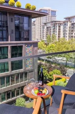 a table with a bottle of wine and fruit on a balcony at Meroddi Beyoğlu Residence in Istanbul