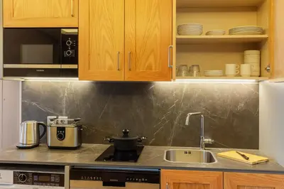 a kitchen with a sink and a stove and cabinets at Meroddi Beyoğlu Residence in Istanbul
