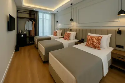 a hotel room with three beds and a tv at Center Port Hotel Karaköy in Istanbul