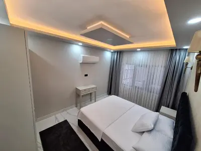 a small bedroom with a white bed and a couch at Daly Resort 1 in Sapanca