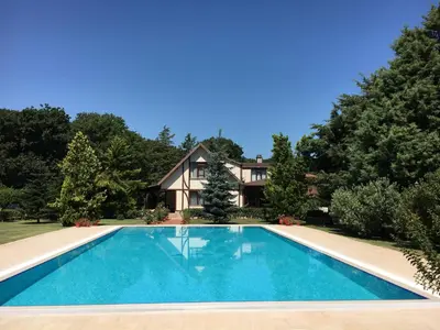 an image of a swimming pool in front of a house at Villa Riva Garden in Polonezkoy