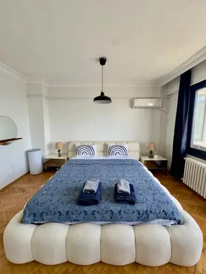 a bedroom with a large bed with a blue blanket at Deluxe Duplex in city center with 210 degrees Bosphorus viewed in Istanbul