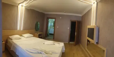 a bedroom with a white bed and a television at City Light Otel in Istanbul