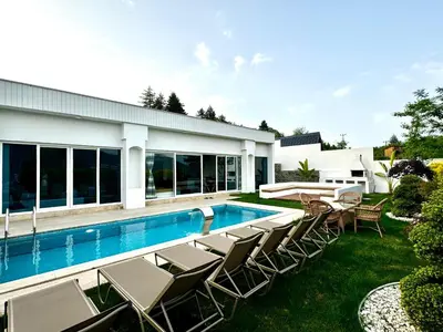a swimming pool with lounge chairs and a house at Sakarya Sapanca Memnuniye de 2 oda 1 salon Özel Havuzlu , Muhafazakar , Şömineli , Jakuzili 6 Kişilik Tatil Villası in Sapanca