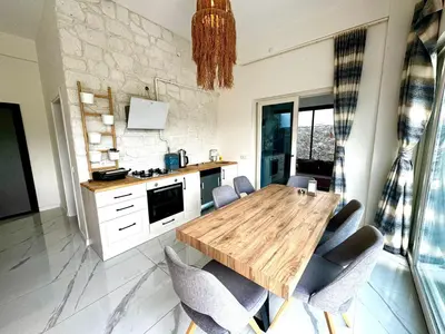 a kitchen with a wooden table and chairs at Sakarya Sapanca Memnuniye de 2 oda 1 salon Özel Havuzlu , Muhafazakar , Şömineli , Jakuzili 6 Kişilik Tatil Villası in Sapanca