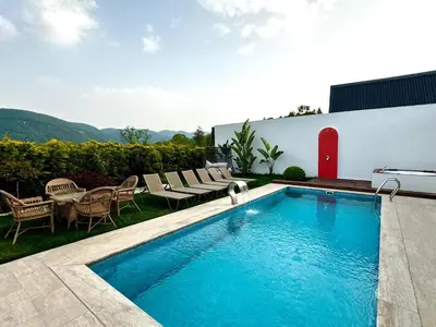 a swimming pool in the backyard of a house at Sakarya Sapanca Memnuniye de 2 oda 1 salon Özel Havuzlu , Muhafazakar , Şömineli , Jakuzili 6 Kişilik Tatil Villası in Sapanca