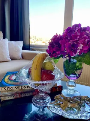 a glass bowl of fruit and flowers on a table at A million dollar view of the Bosporus and balcony in Istanbul
