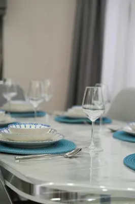 a table with blue and white plates and wine glasses at Kadir Bey Apt in Istanbul