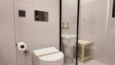 a white bathroom with a toilet and a sink at Yıldız Termal Otel in Çekirge İstasyonu